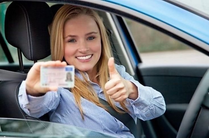 Une conductrice montre son permis de conduire par la vitre de la voiture